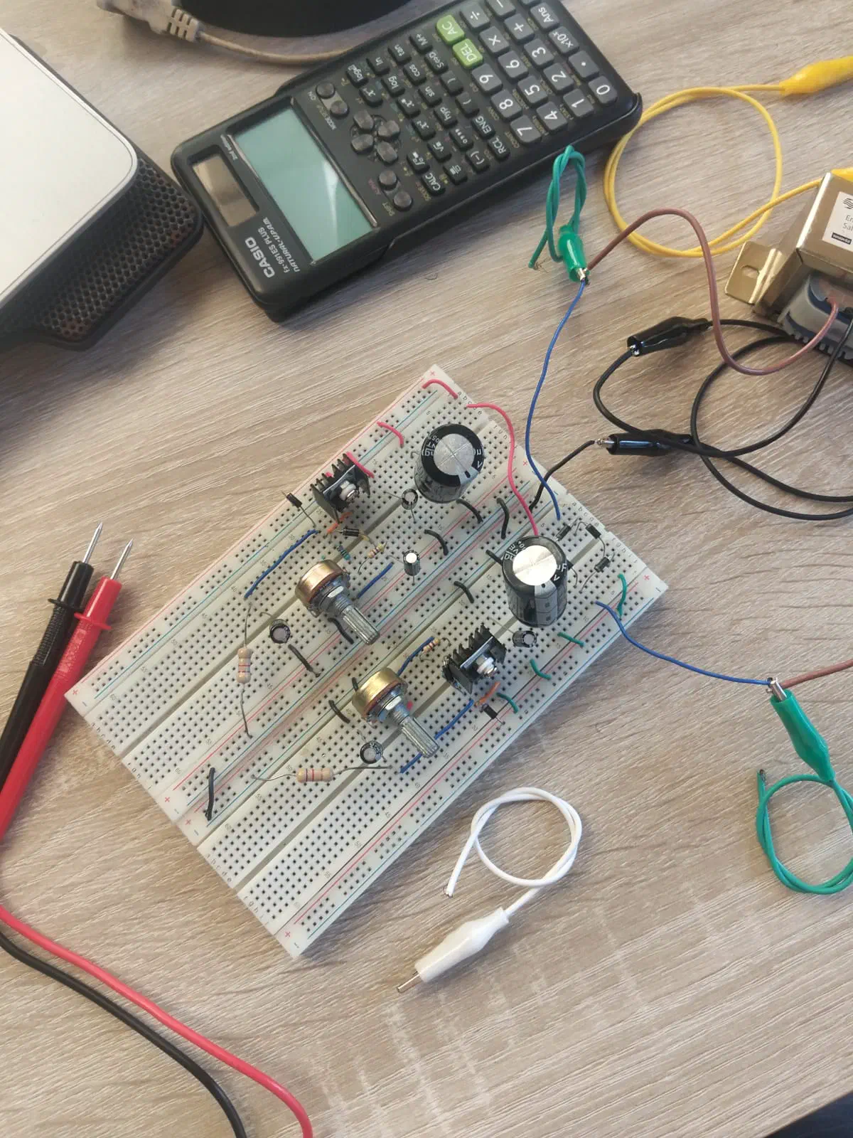 The prototype of the power source with some scattered stuff on the desk